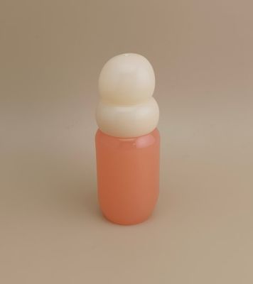 กระป๋องแก้วสีชมพูที่มีฝาปิดสีขาวสําหรับน้ําหอมของผู้หญิง